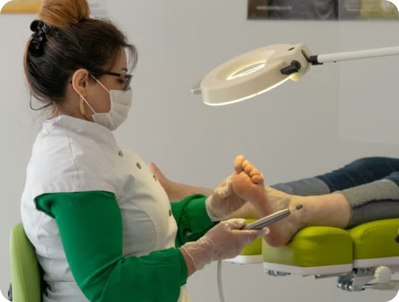 Podiatrist treating a patient's foot in the clinic chair