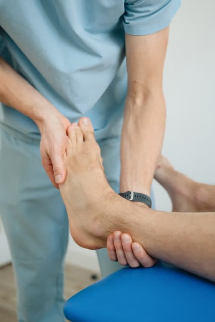 Podiatrist examining a patient's foot and ankle