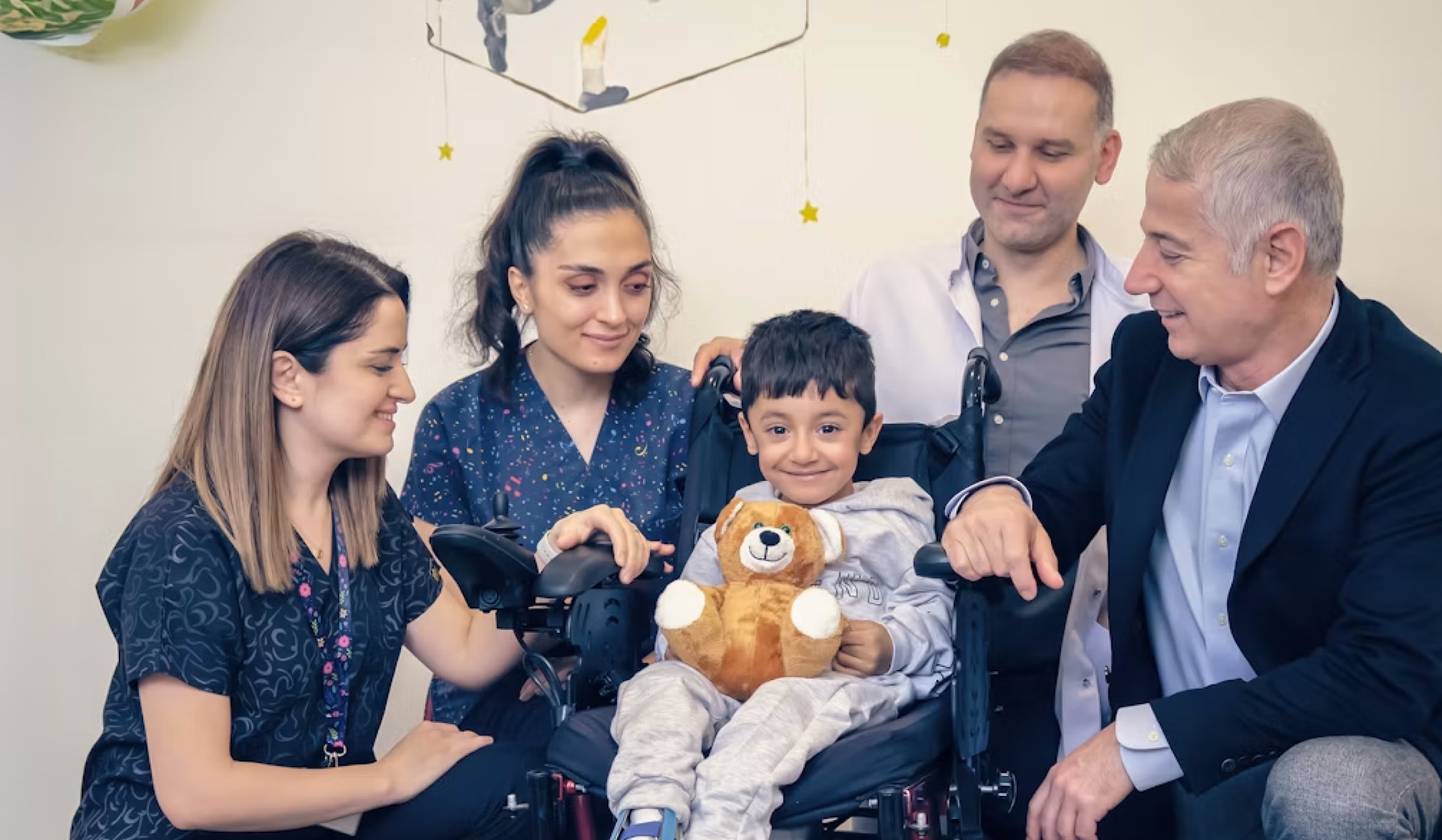 Smiling child in a wheelchair with family — podiatry care for every patient Smiling child in a wheelchair with family — podiatry care for every patient