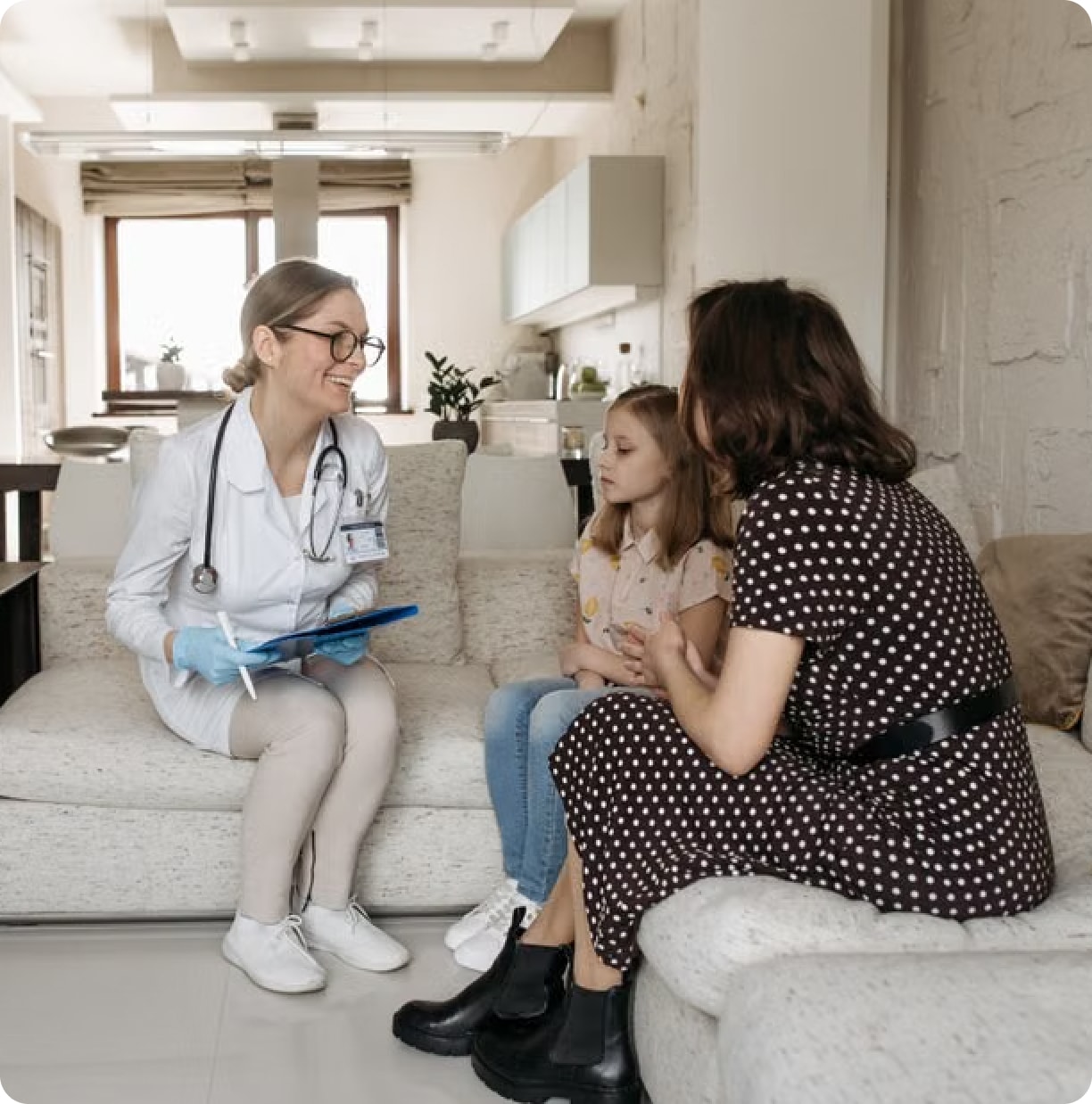 Clinician in a white coat talking with a mother and daughter at home Clinician in a white coat talking with a mother and daughter at home