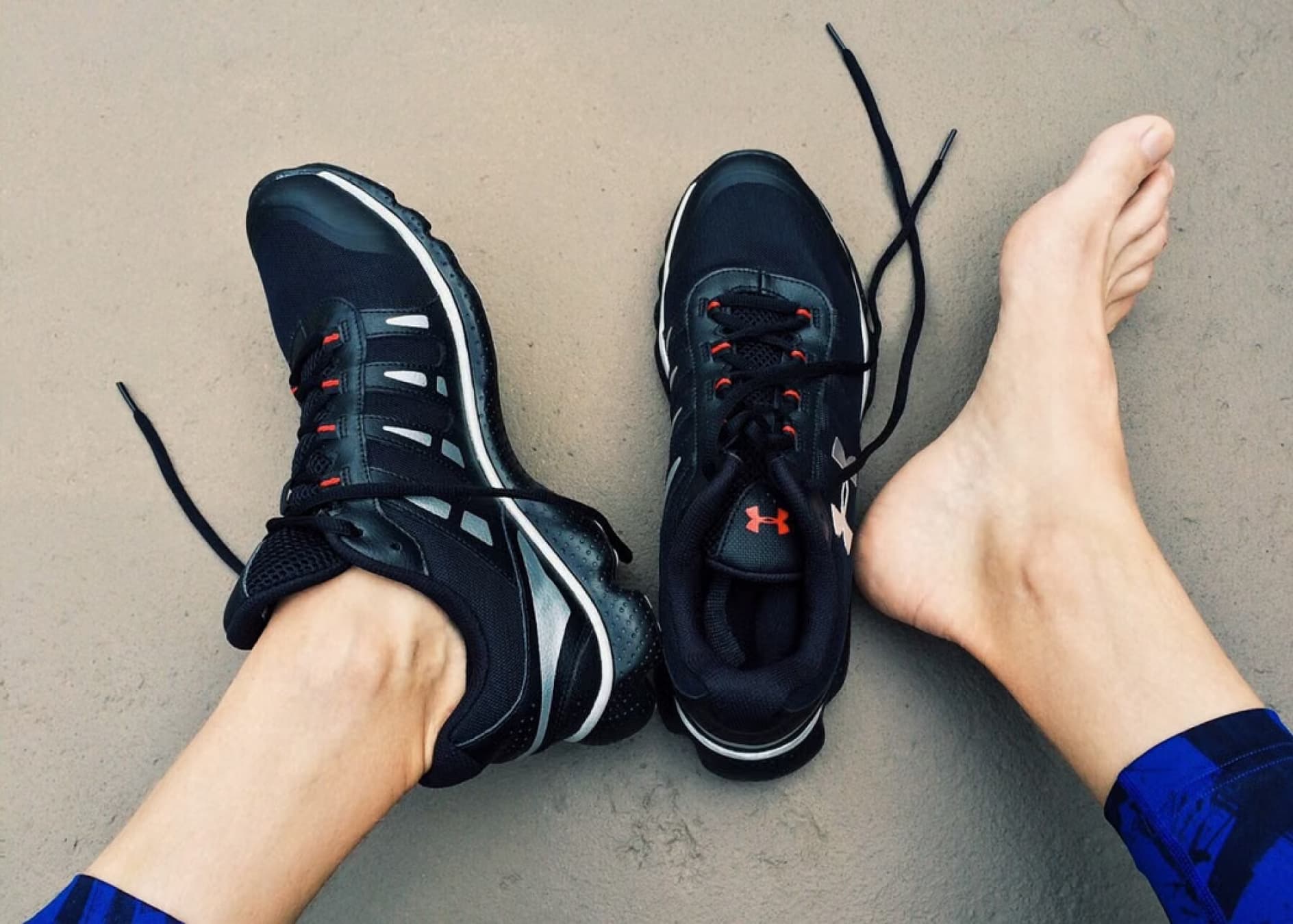Bare foot resting beside a pair of running shoes