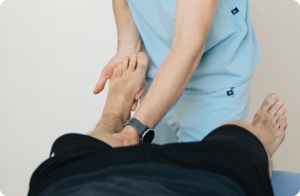 Clinician supporting a patient's foot during treatment
